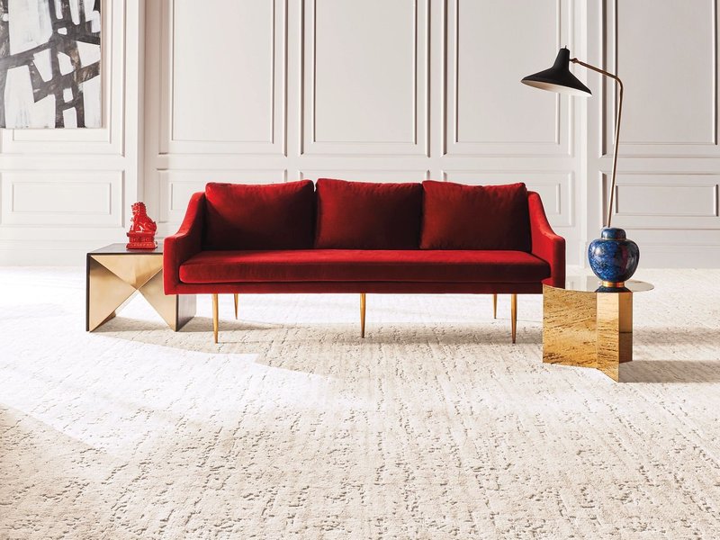Bright living room with a red velvet couch and beige textured carpet from Simonian Flooring Inc in Village, NV